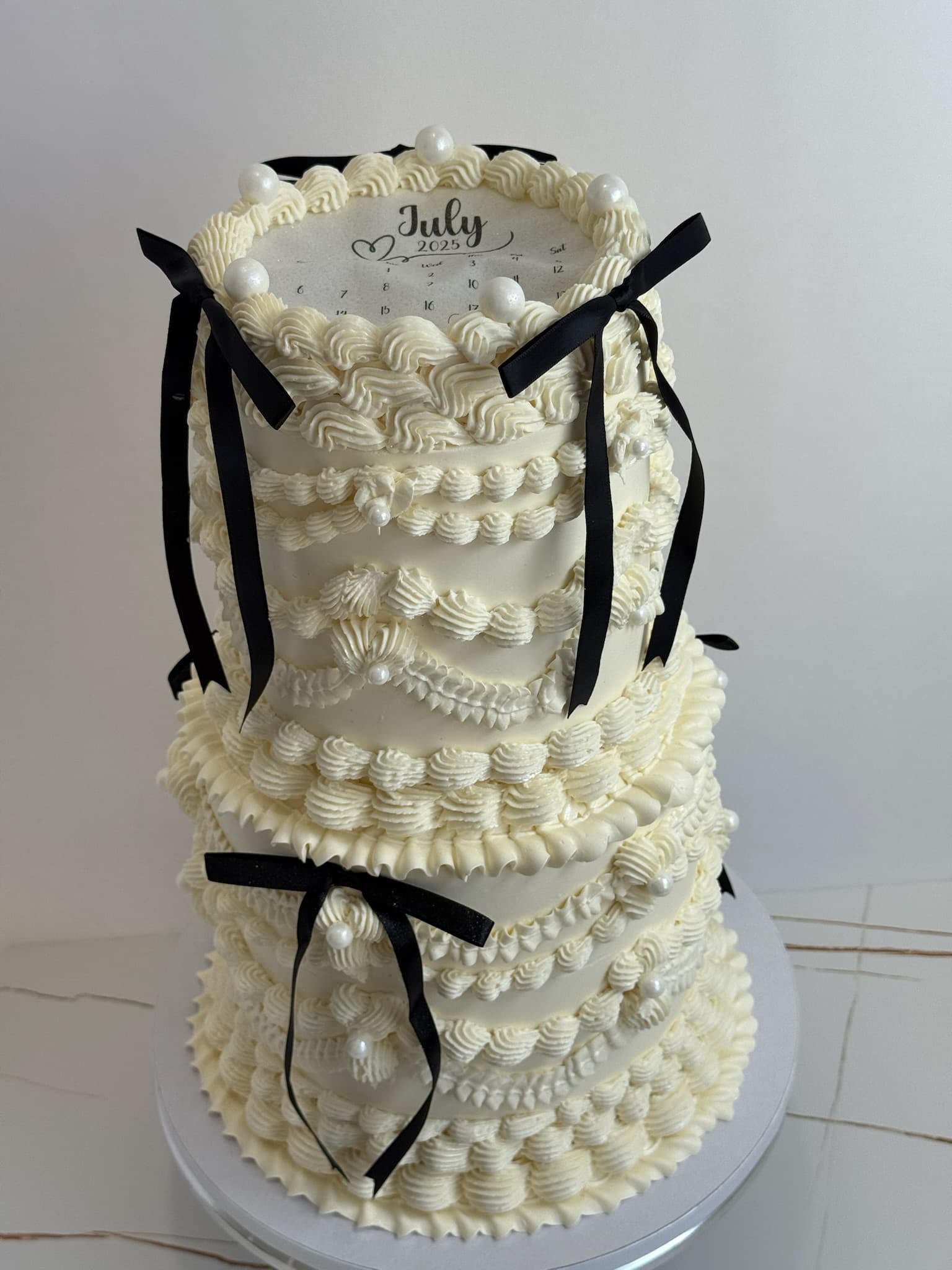 Vintage lambeth three-tier wedding cake with black bows
