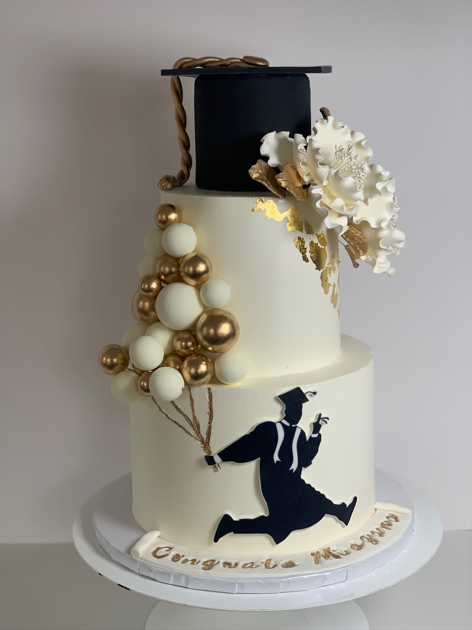 Black and gold graduation silhouette cake close-up